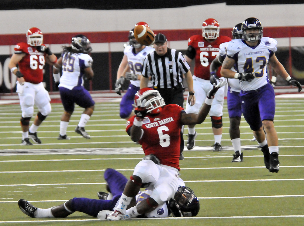 South Dakota wide receiver Terrance Terry, 6, tries to find the ball after it got tipped up as he was hit by a Western Illinois defender. The ball fell out of his reach.